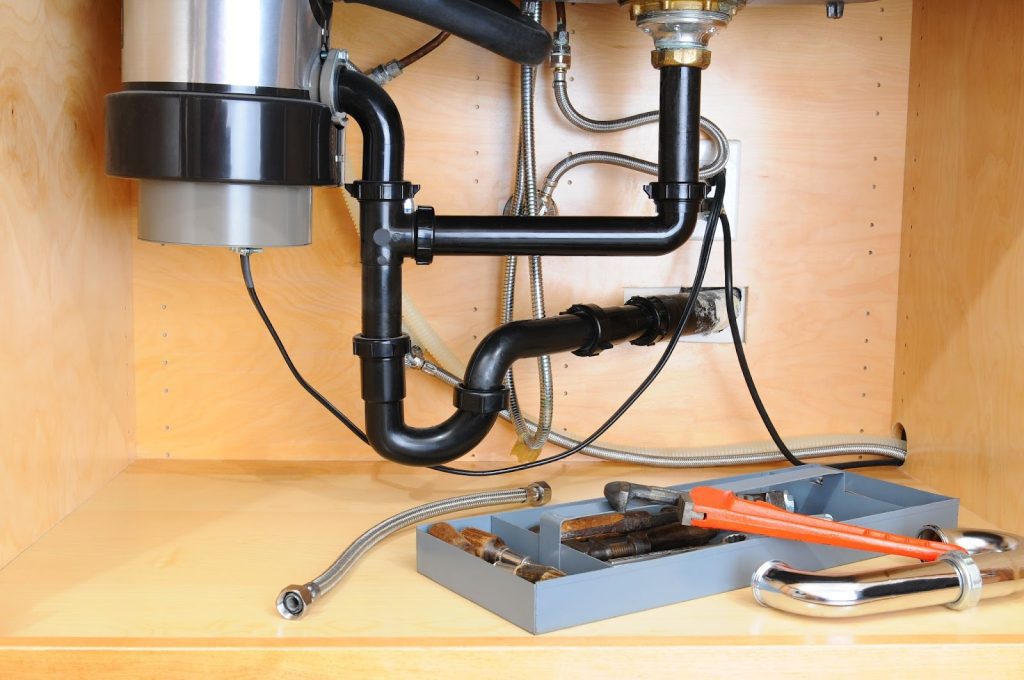 Sink under cabinet with garbage disposal, needs repair. Contact professional plumber for effective solution.