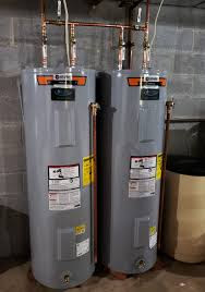 Three water heaters surrounded by pipes and valves.