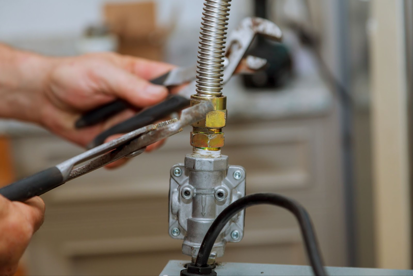 A man repairs a pipe with a wrench, ensuring safety in commercial gas line installations and maintenance.